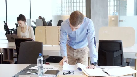 Young working businessman sort out working papers for analitic tasks Stock-Footage 73239117