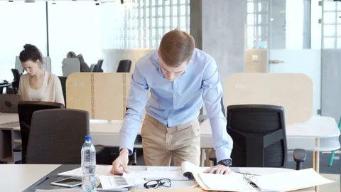 Young working businessman sort out working papers for analitic tasks Stock Footage 73239818