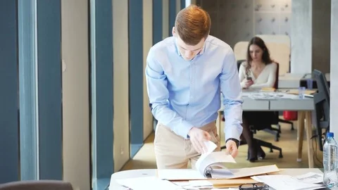 Young working businessman sort out working papers for analitic tasks Stock Footage 73240635