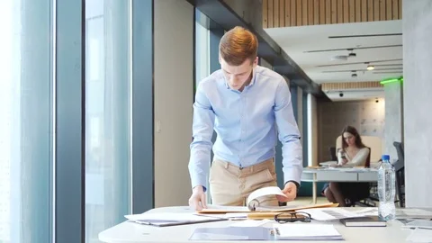 Young working businessman sort out working papers for analitic tasks Stock Footage 73240851