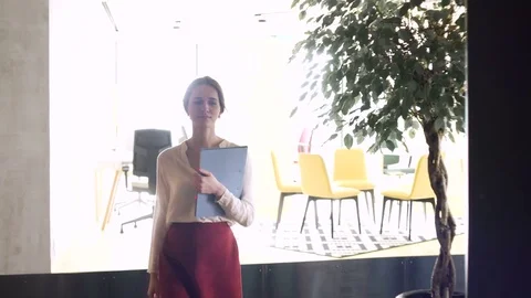 Young working woman go with document case in hands through the office during Stock Footage 80084710