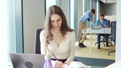 Young working woman use mobile telephone during working on laptop computer in Vídeo Stock 73353530