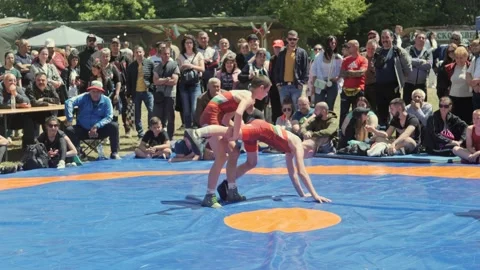 Young wrestlers grapple in tournament ring watched by crowds of spectators Stock Footage 192881034