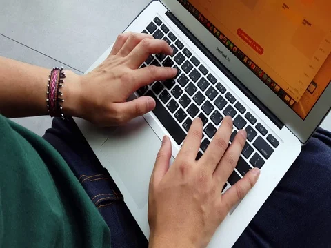 Young writer typing on a macbook computer Stock Footage 72782254