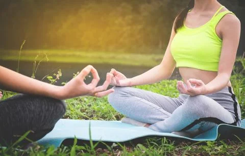 Young yoga practitioners in group doing yoga on nature, healthy lifestyle con Stock Photos