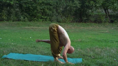 Young Yogi Practicing Asanas, Performing Exercises on a Glade in the City Park Stock Footage 85745389