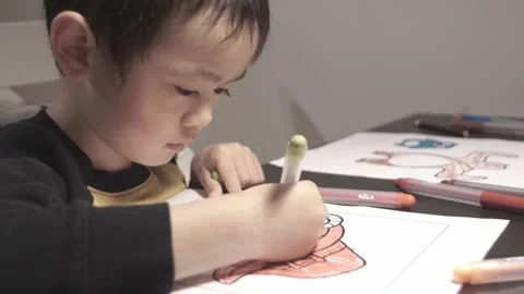 Younger brother drawing while older brother watches Stock Footage 220960072