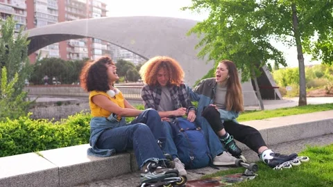 Youngsters sharing laughter after roller skating in urban park Stock Footage 312812151