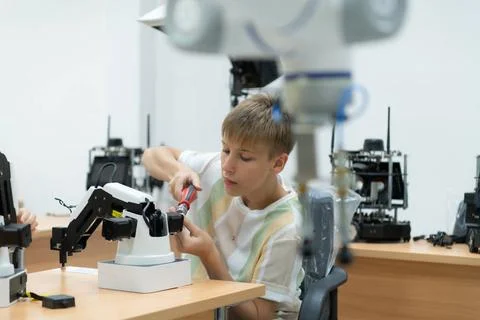 Youngsters utilizing the hand robot technology are having fun learning the... Stock-Fotos