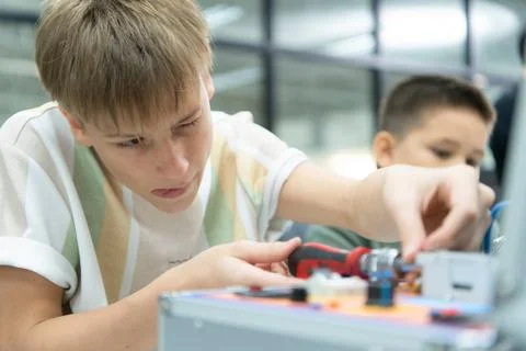 Youngsters utilizing the hand robot technology are having fun learning the... Stock-Fotos