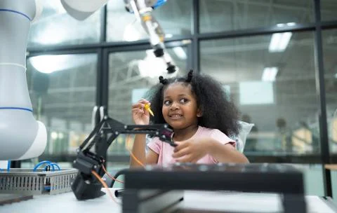 Youngsters utilizing the hand robot technology are having fun learning the... Stock-Fotos