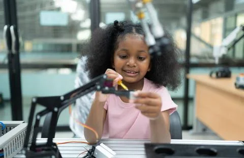 Youngsters utilizing the hand robot technology are having fun learning the... Stock-Fotos