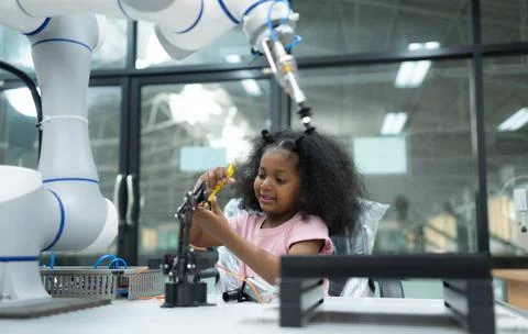 Youngsters utilizing the hand robot technology are having fun learning the... Stock-Fotos