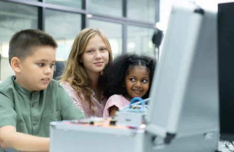 Youngsters utilizing the hand robot technology are having fun learning the... Stock-Fotos