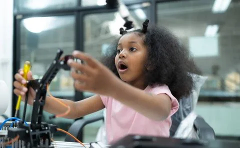 Youngsters utilizing the hand robot technology are having fun learning the... Stock-Fotos
