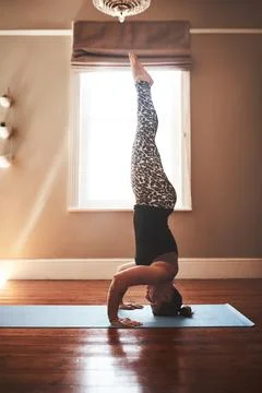 Your core will keep you up. a young woman practising yoga at home. Stock Photos