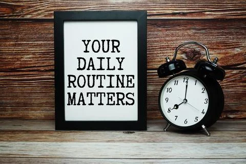 Your Daily Routine Matters text with alarm clock on wooden background Stock Photos