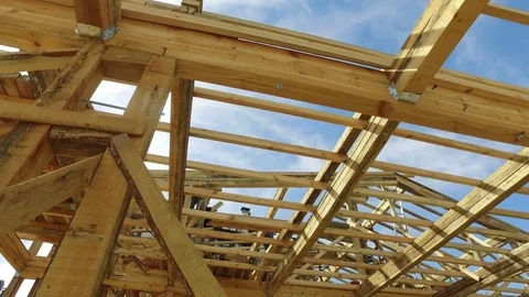Your dream home. New residential construction house framing against a blue sky Stock Footage 70488341