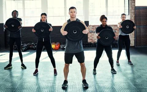Your effort makes all the difference. a fitness group using kettle-bells in Stock Photos