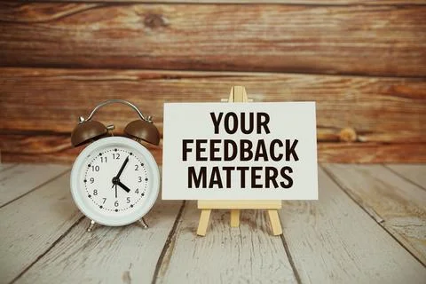 Your Feedback Matters text with easel and alarm clock on wooden background Stock Photos