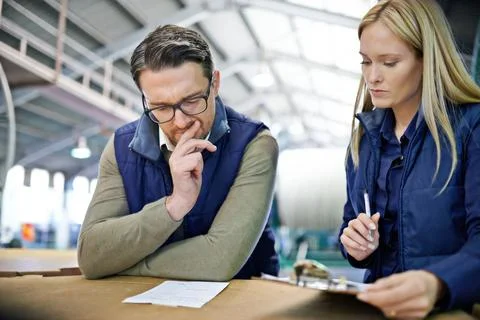 Your order is in their capable hands. a two coworkers managing a warehouse. Stock Photos