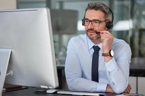 Your problem my priority. a mature male call center agent working in a modern 스톡 사진