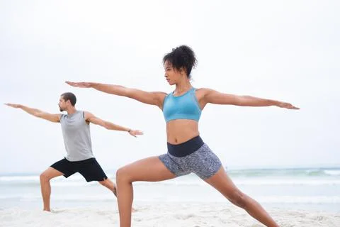 Your transformative journey starts now. a young man and woman practising yoga Stock Photos