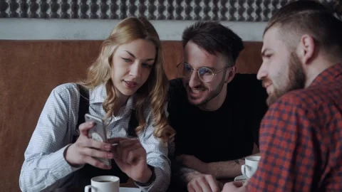 Youth are at the cafe sharing some news and discussing something staring at the Stock Footage 159085264