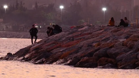 Youth are resting on Seaside at Sunset Stock Footage 123765979