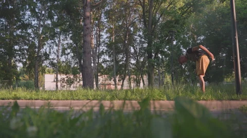 Youth Bends Down, Young Individual Carefully Picks Up Object Outside, Young Man Stock Footage 327154884