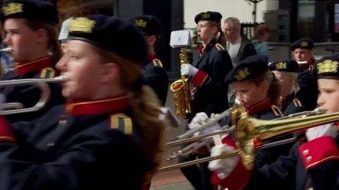 Youth brass marching band playing drums and saxophones in Oosterbeek parade Видео 346007675