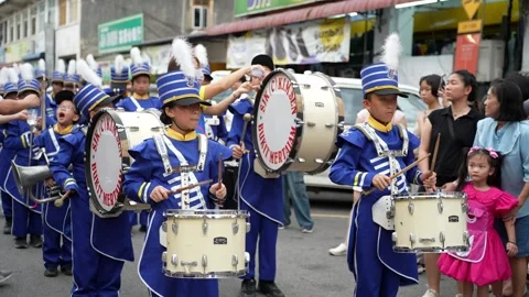 Youth Marching Band Procession Through Busy City Street Vidéo 345929369