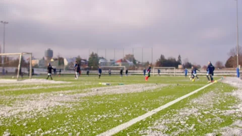 Youth soccer players are playing on a turf field in an urban setting with buildi Stock Footage 295931453