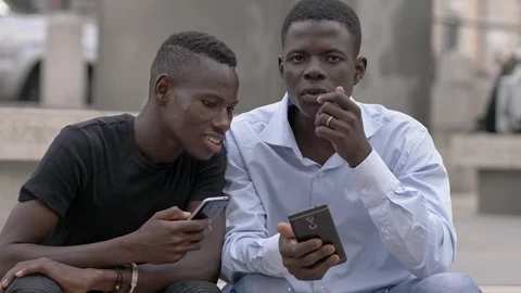 Youth,communication devices.  american african men in the street using smartphon Stock Footage
