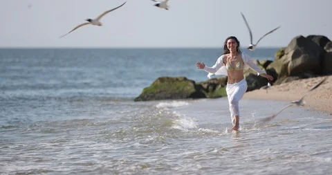 Youthful_Lady_Chases_Birds_on_Beach Stock Footage