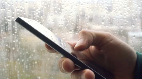 Ypung man browsing information on smartphone with drops on background Stock Footage 83708233