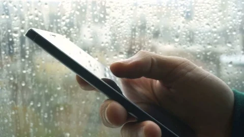 Ypung man browsing information on smartphone with drops on background Stock Footage 83783689