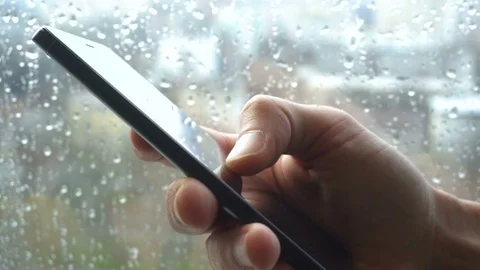 Ypung man browsing information on smartphone with drops on background Stock Footage 83784108
