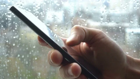 Ypung man browsing information on smartphone with drops on background Stock Footage 83818940