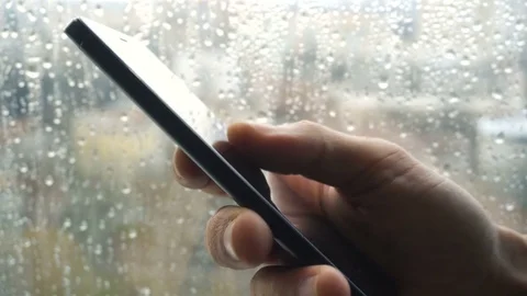 Ypung man browsing information on smartphone with drops on background Video stock 84258560