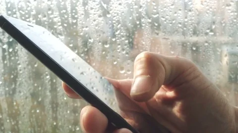 Ypung man browsing information on smartphone with drops on background Video stock 84259039