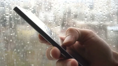 Ypung man browsing information on smartphone with drops on background Stock Footage 84293949