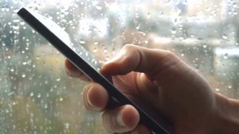 Ypung man browsing information on smartphone with drops on background Stock Footage 84489359