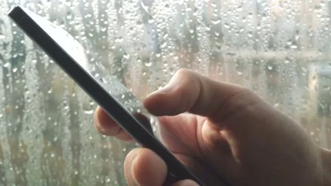 Ypung man browsing information on smartphone with drops on background Stock Footage 84490272