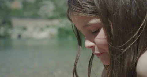 Yumi eating a cherry close up next to the river in pont du diable occitanie Stock Footage 132797425