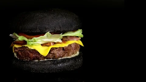 Yummy Black Cheeseburger, copy space on right side, black background, loop Stock Footage 75253735