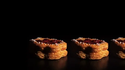 Yummy delicious flavored cake with cherry jam rotates on a dark, black backgr 스톡 동영상 84741141