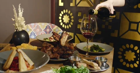 Yummy eastern cuisine served in the restaurant. Georgian food. Red wine pouring Stock Footage 320469827