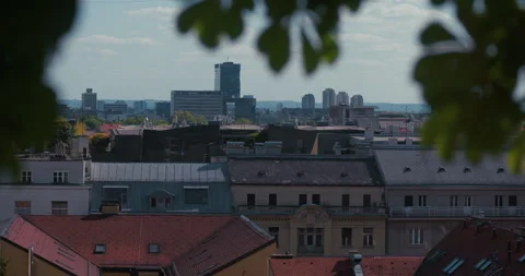 Zagreb rooftops and skyline framed by tree leaves Vídeos de archivo 334443948