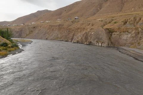 Zarafshon River flows through rugged terrain in Tajikistan's landscape Stock Photos